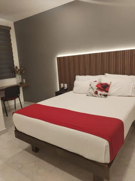 Comfortable guest room with a red bed runner and work desk